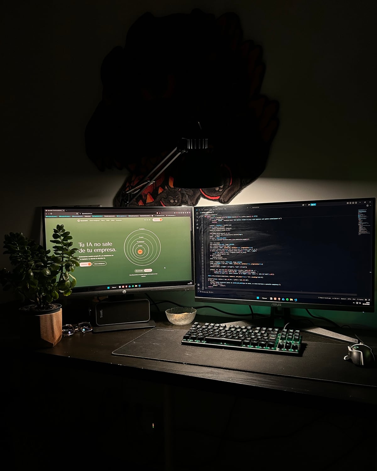 El escritorio de Pablo de noche, con la web de DynamisAI en una pantalla y código en la otra